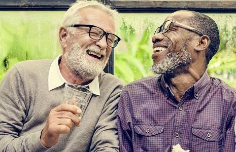Two older men sitting together laughing
