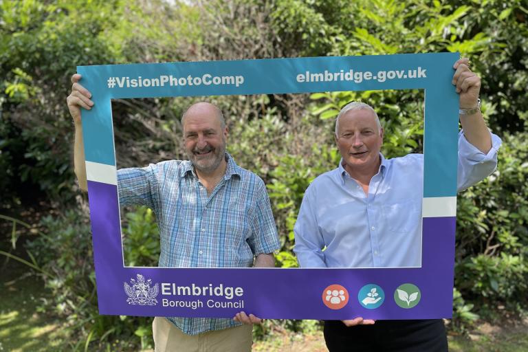 Cllr Bruce McDonald and Cllr Simon Waugh holding the official selfie frame for the Elmbridge Borough Council Vision Photo Competition.