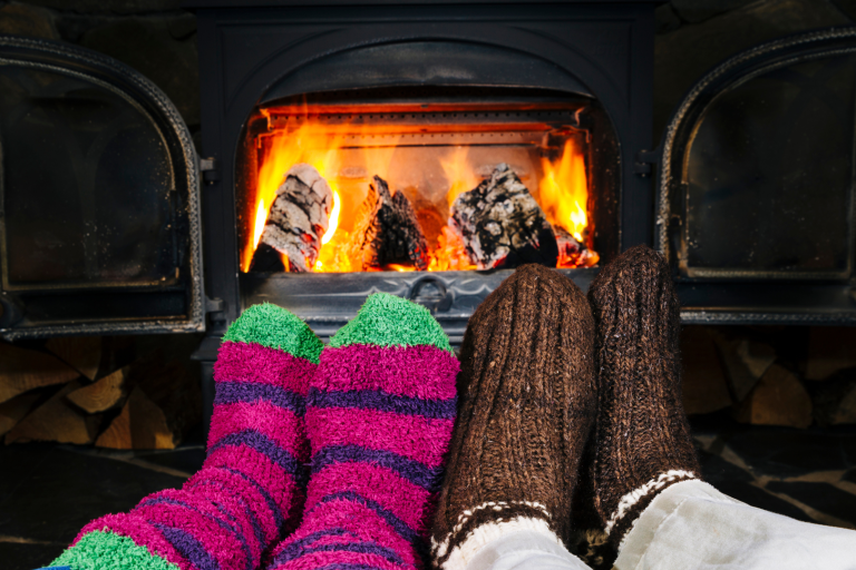 Feet in fluffy socks in front of a wood burning stove