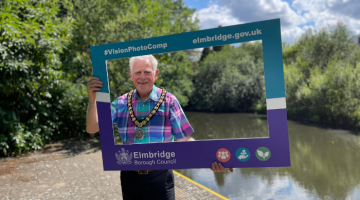 Mayor of Elmbridge holding the official selfie frame for the Vision Photo Competition.