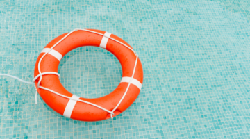 An orange rescue ring floating in a pool.