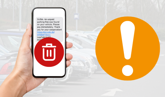 A mobile phone with scam text message being held with a red delete button over it against a background of a car park. To the right is an orange circle with an exclamation mark to represent a warning.