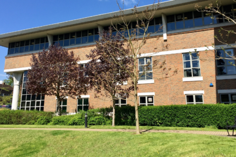 Exterior of the Elmbridge civic centre behind trees.