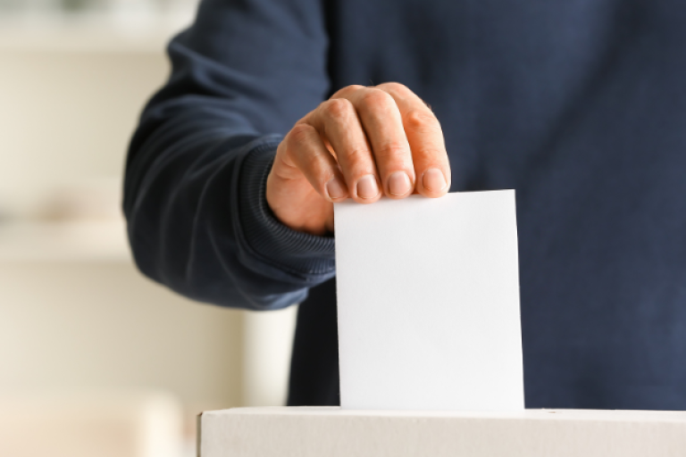 A person placing a card into a ballot box