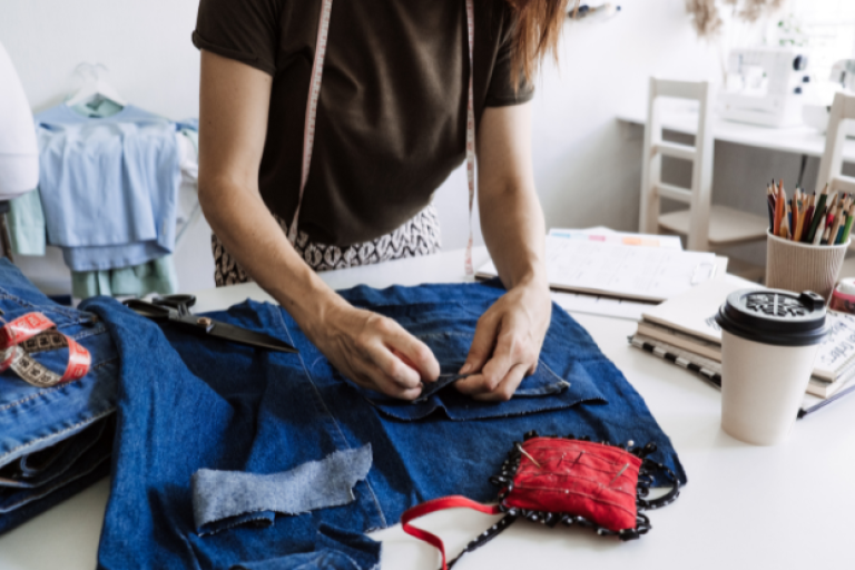 An image of a person sewing clothes.