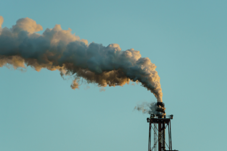 An image of a chimney releasing greenhouse gasses into the atmosphere