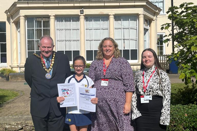 Cllr Neil Houston Mayor of Elmbridge, prize winner Belle, Kim Tagliarini Strategic Director Elmbridge Borough Council, Tamsin Vigar, Community Safety Officer Elmbridge Borough Council standing on grass in front of building