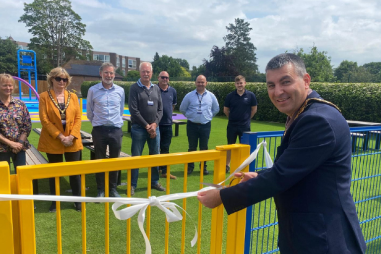 Mayor Steve Bax cuts white ribbon at Weybridge splash pad