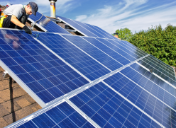 Man installing solar panels on a roof