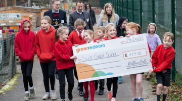 Pupils at Esher Church School carrying a large cheque from Green Redeem after winning a recycling competition.