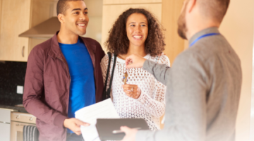 Estate agent handing keys to buyers