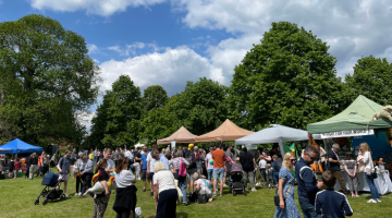 People attending a summer fair with market stalls