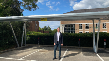 Cllr Young in front of the solar car port