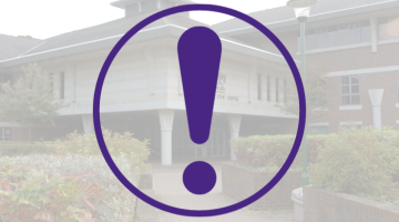 Alert symbol against the backdrop of a photo of the Civic Centre in Esher