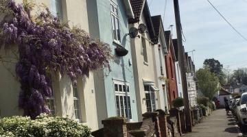 A street of terraced houses, each house painted a different pastel colour