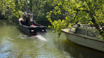 Unauthorised boat on Cigarette Island being towed away